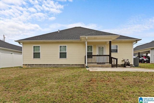 back of house with a patio and a lawn