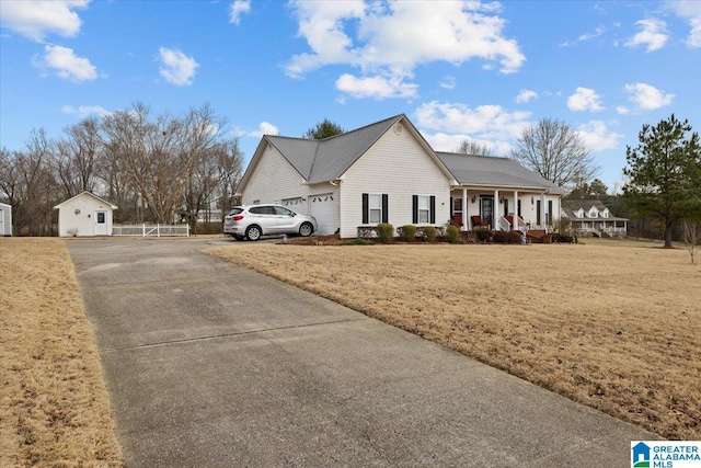 view of side of home featuring a garage, driveway, a porch, and a lawn