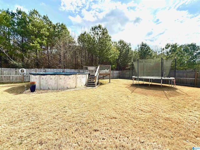 view of yard featuring a covered pool and a trampoline