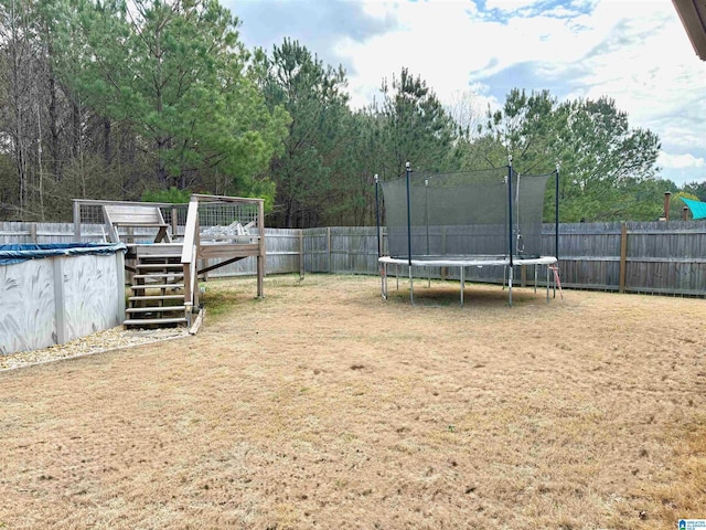 view of yard featuring a covered pool and a trampoline