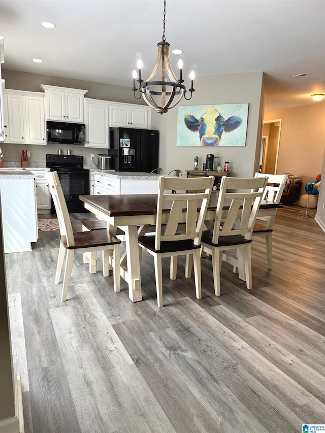 dining area with an inviting chandelier and light hardwood / wood-style floors