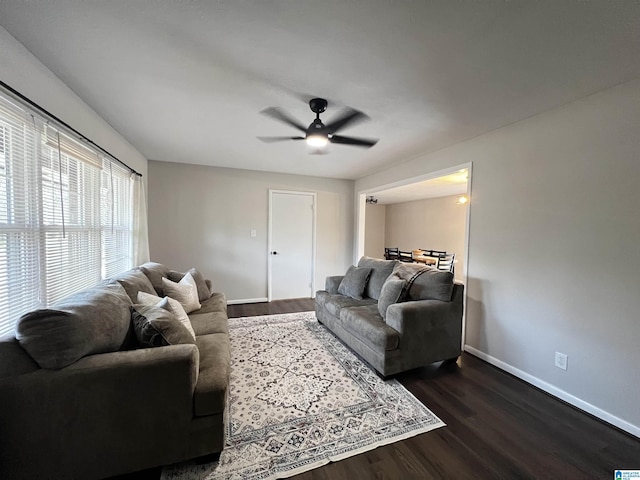 living room with dark wood-type flooring and ceiling fan