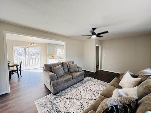 living room featuring ceiling fan and dark hardwood / wood-style floors