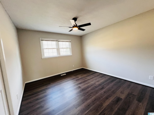 empty room featuring dark wood-type flooring and ceiling fan