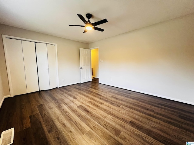 unfurnished bedroom with hardwood / wood-style floors, a closet, and ceiling fan