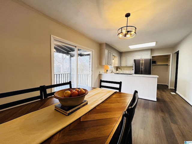 dining area with sink and dark wood-type flooring