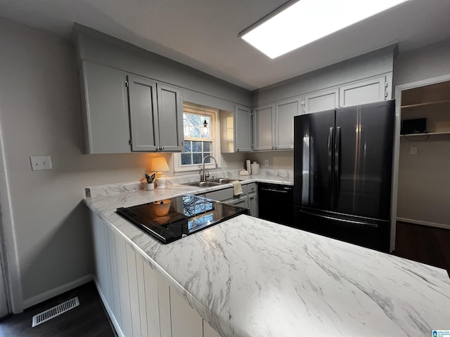 kitchen with gray cabinetry, kitchen peninsula, sink, and black appliances