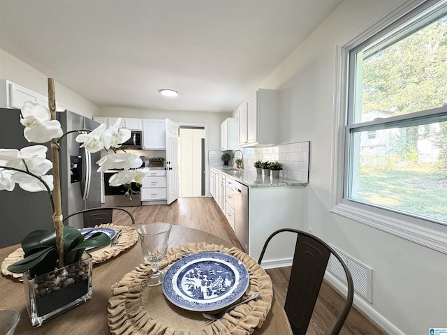 dining area featuring wood-type flooring and sink