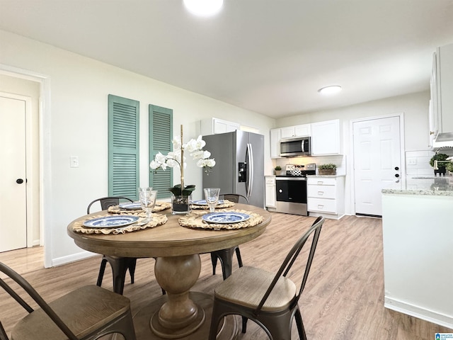 dining space with sink and light wood-type flooring