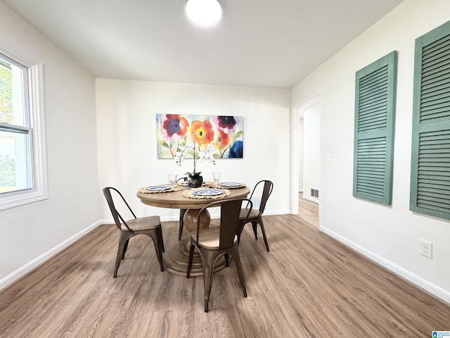 dining space with hardwood / wood-style flooring