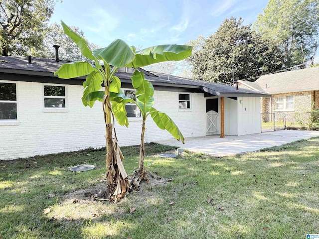 back of property with a yard and a patio