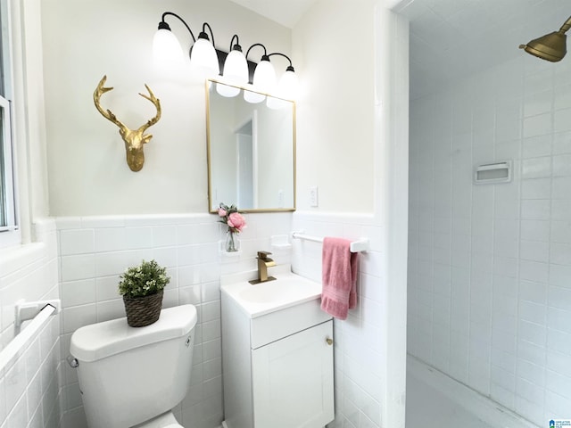 bathroom with vanity, toilet, and tile walls