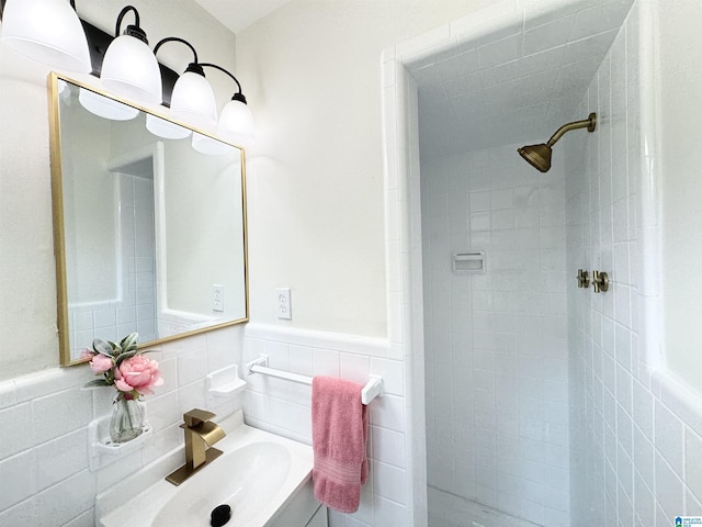 bathroom with a tile shower, sink, and tile walls