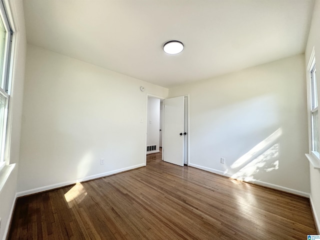 unfurnished room featuring dark hardwood / wood-style flooring