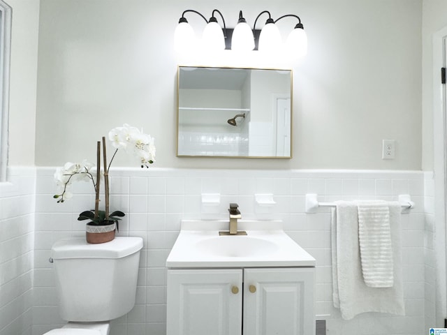 bathroom with vanity, tile walls, and toilet