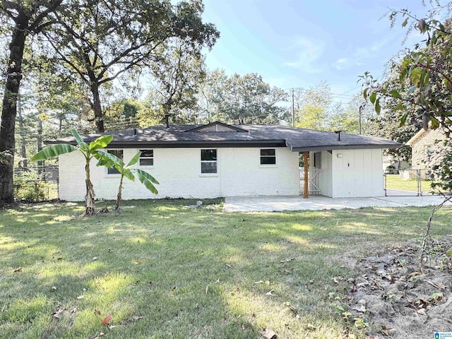 rear view of house with a yard and a patio