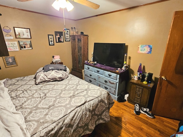 bedroom with ornamental molding, hardwood / wood-style floors, and ceiling fan