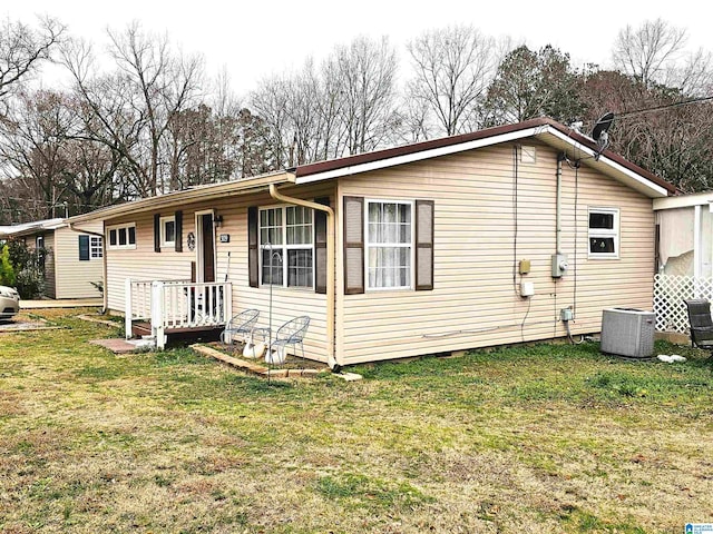 view of front of home with central AC unit and a front yard