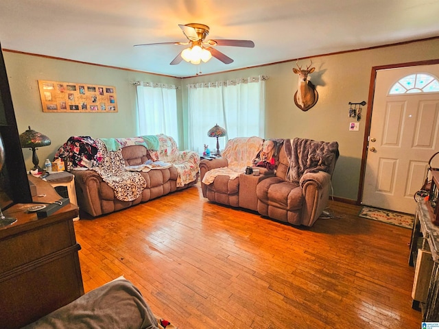 living room with hardwood / wood-style floors, ornamental molding, and a wealth of natural light