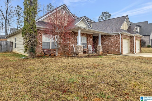 view of front of property featuring a garage, covered porch, and a front yard