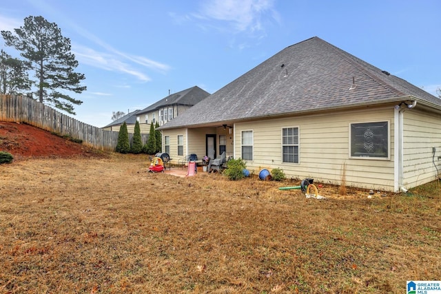 rear view of house featuring a yard and a patio area