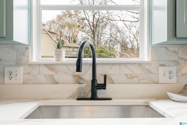 details featuring sink, backsplash, and green cabinets