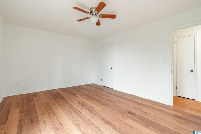 empty room with ceiling fan and light hardwood / wood-style floors