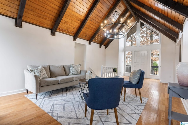 living room featuring high vaulted ceiling, wooden ceiling, light wood-type flooring, a notable chandelier, and beamed ceiling