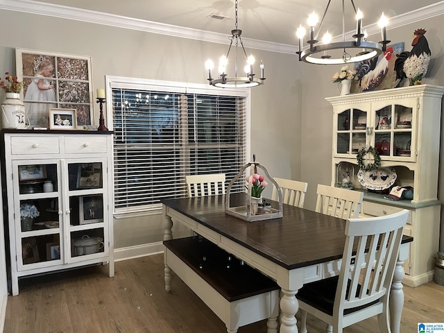 dining room featuring crown molding, a chandelier, and hardwood / wood-style flooring