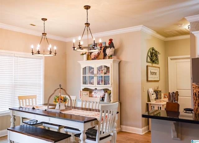 dining area featuring crown molding, a chandelier, and light hardwood / wood-style floors