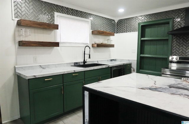 kitchen featuring light stone counters, stainless steel range with electric stovetop, sink, and green cabinets