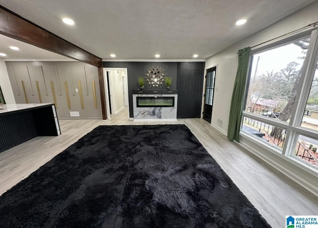 unfurnished living room featuring light hardwood / wood-style floors and a textured ceiling