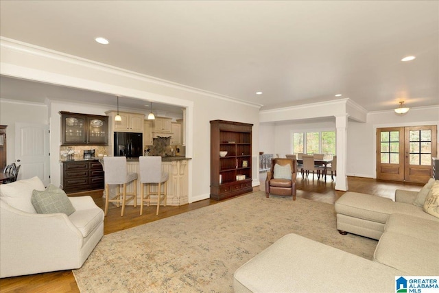 living room with hardwood / wood-style flooring, crown molding, and french doors