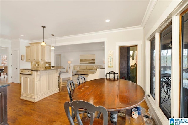 dining room featuring ornamental molding and light hardwood / wood-style flooring