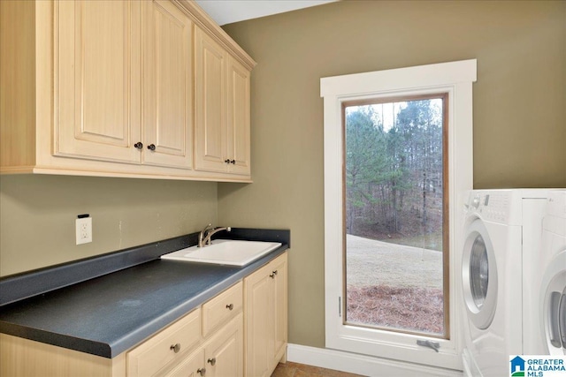 clothes washing area featuring sink, washer / clothes dryer, and cabinets