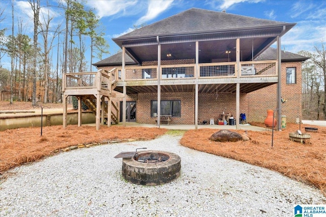 rear view of house featuring a wooden deck, a patio area, ceiling fan, and a fire pit