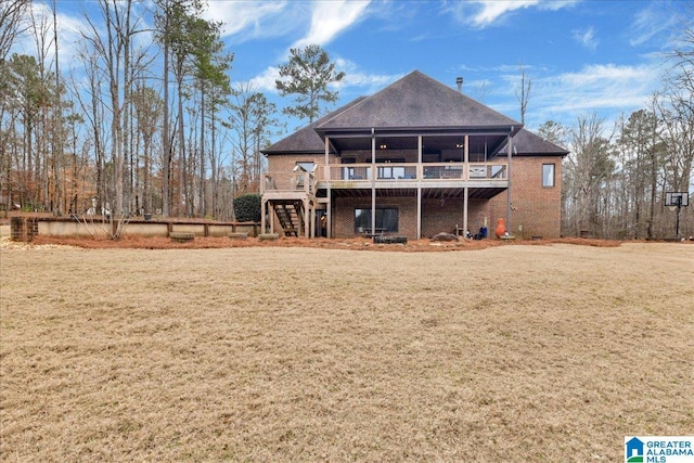 rear view of property featuring a wooden deck and a yard