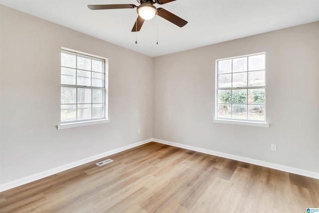 empty room with ceiling fan and light hardwood / wood-style flooring