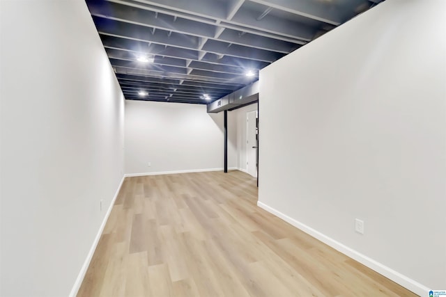 basement with light hardwood / wood-style flooring