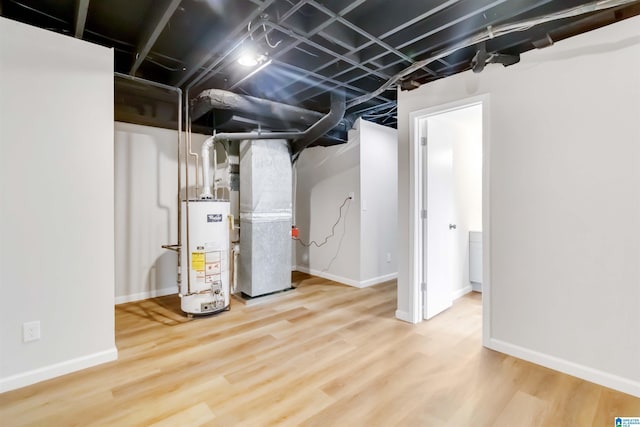 basement with heating unit, wood-type flooring, and water heater