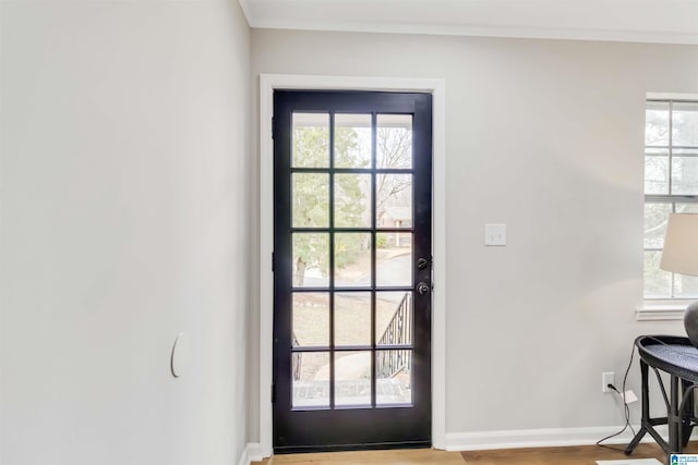 doorway featuring ornamental molding and light hardwood / wood-style floors