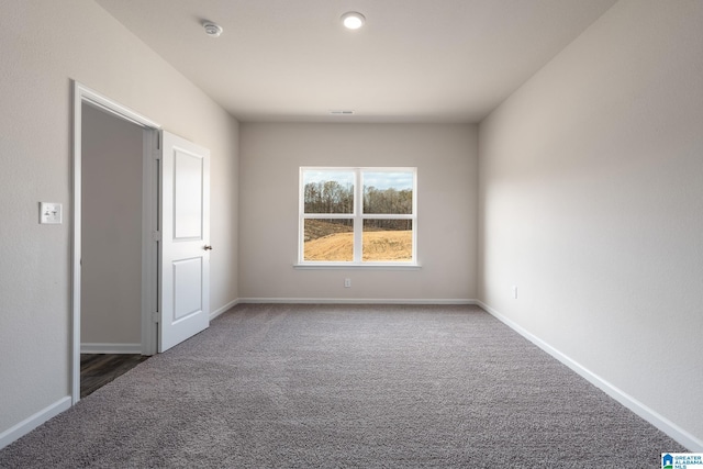 empty room with dark colored carpet