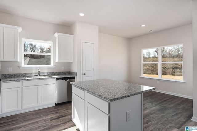 kitchen featuring sink, light stone countertops, white cabinets, a kitchen island, and stainless steel dishwasher