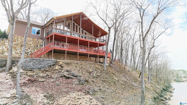 back of property with a wooden deck and a balcony