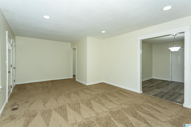 empty room featuring carpet and a textured ceiling