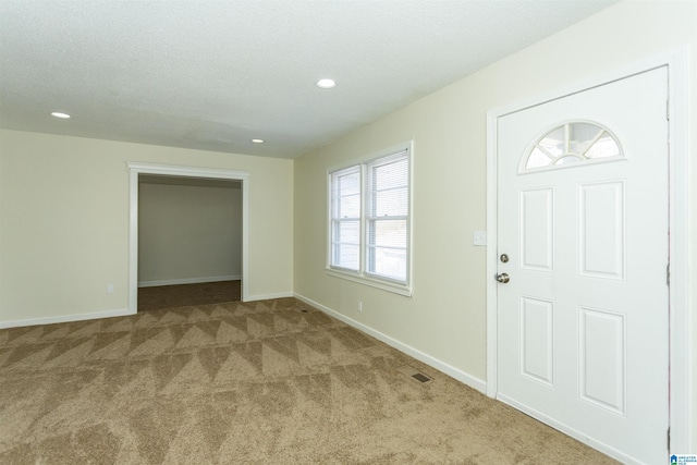 carpeted entrance foyer featuring a textured ceiling