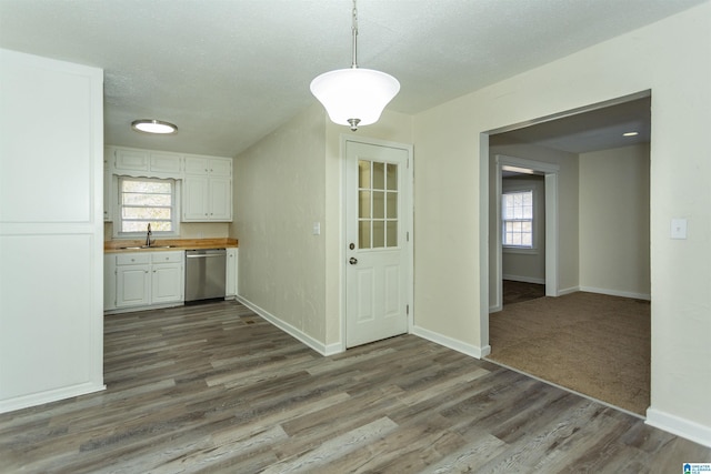 unfurnished dining area with sink, dark hardwood / wood-style floors, a wealth of natural light, and a textured ceiling