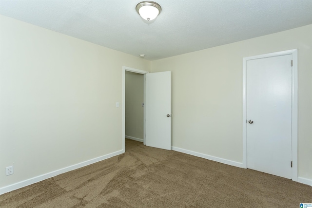 spare room featuring carpet floors and a textured ceiling