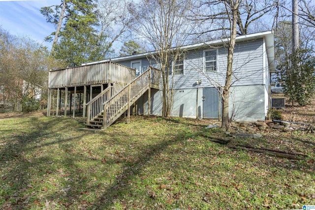 back of property featuring a wooden deck and a yard