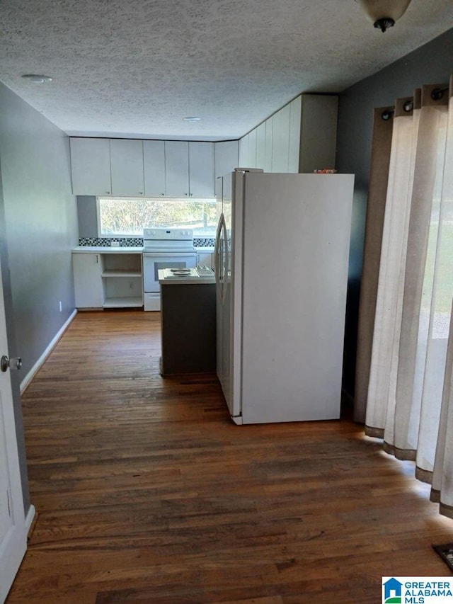 kitchen featuring dark wood-type flooring, white appliances, a textured ceiling, and white cabinets